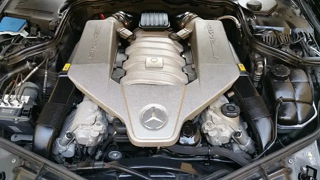 Motorraum eines Mercedes mit abgedeckter V8-Maschine und sichtbarem Stern auf der Motorabdeckung