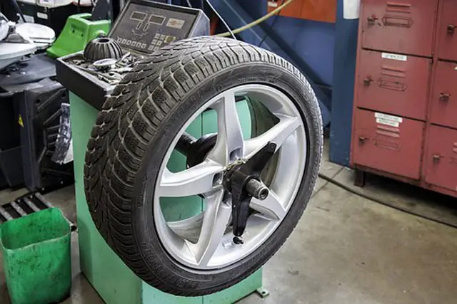 Rad mit Leichtmetallfelge auf einer Auswuchtmaschine in der Werkstatt